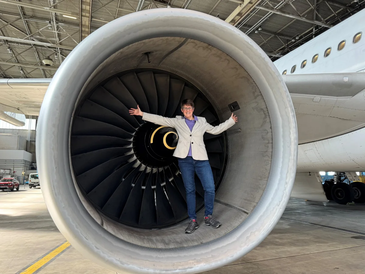 Wiebke Reerink vor einem großen Flugzeugtriebwerk in einem Hangar.